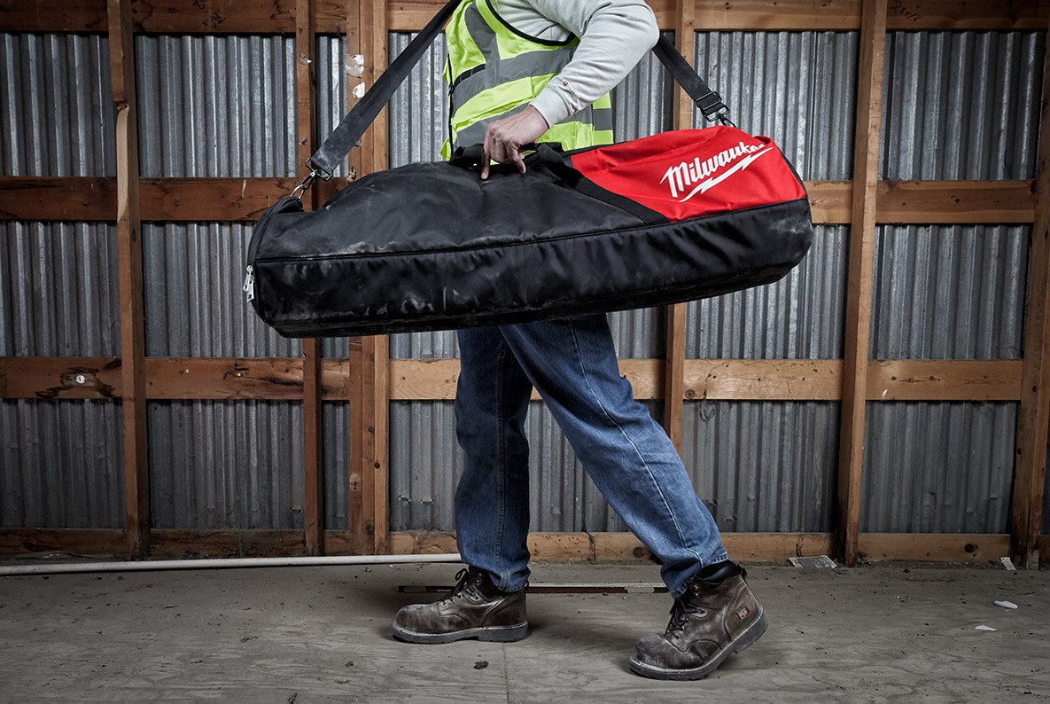 Milwaukee M18 Rocket Tower Light being carried in carrying case which is included with the Kit, showing that it is compact and easy to transport.