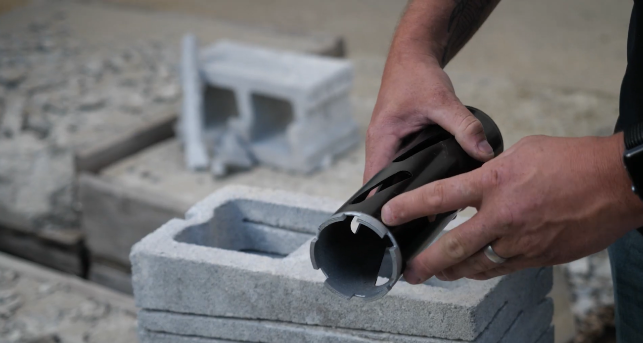 Pointing to the carbide tips on a dry carbide core bit, which cores holes using force and impact.