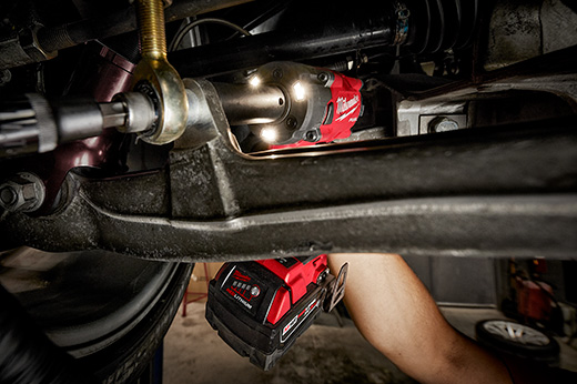 Mechanic using a Milwaukee Stubby Impact Wrench to fasten bolts under a car