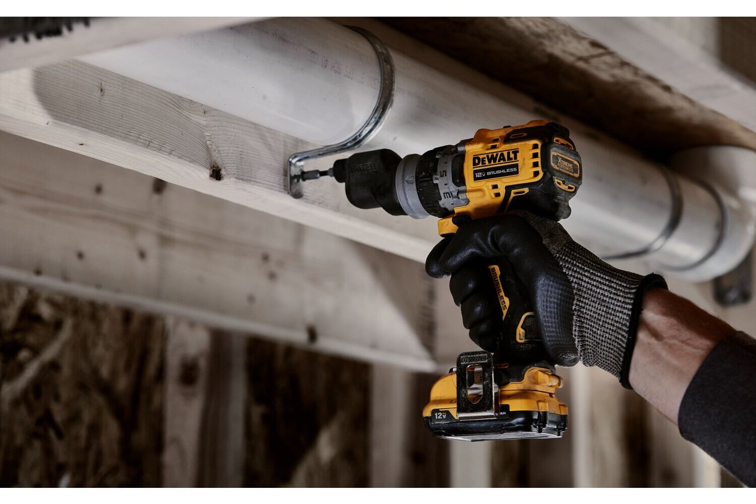 The 12V MAX 5-in-1 Drill/Driver is used to fasten a fixture around a pipe. 